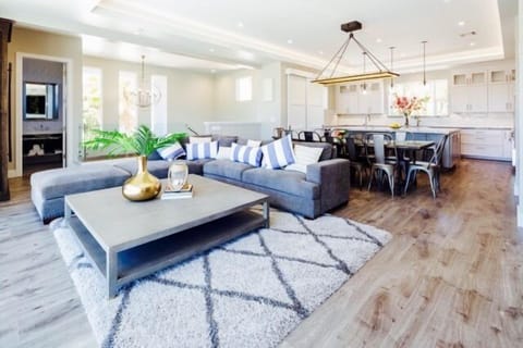 Living Room - Open grande living, dining and kitchen area. Located on the third level. Living room windows open panoramic doors to large deck with sofa seating. Up a flight of stairs to the upper deck to dining table for 6, sectional seating and BBQ center.