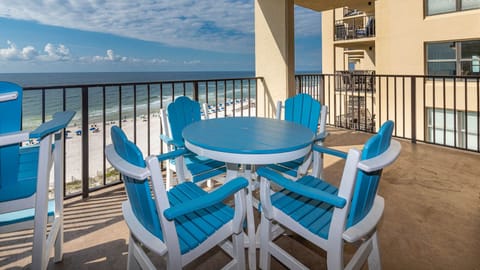 A vibrant blue table with matching chairs offers a perfect spot to enjoy the beach front view and gentle beach waves