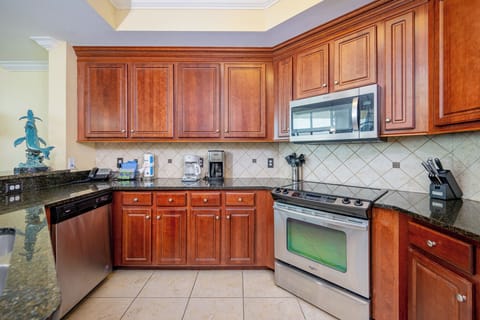 Bright kitchen featuring rich wood cabinetry, stainless appliances, and a granite countertop, perfect for culinary adventures