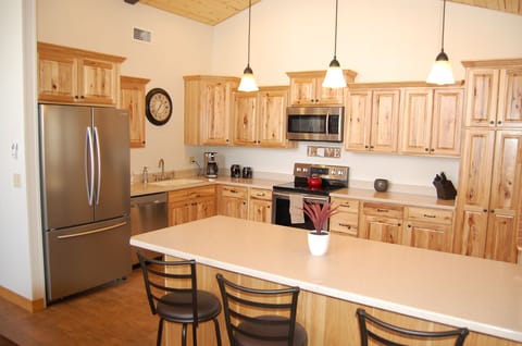 Kitchen with new stainless appliances, hickory cabinets and a breakfast bar.
