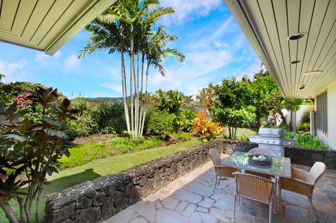 Outdoor lanai with Bar-B-Que and seating surrounded by a tropical garden