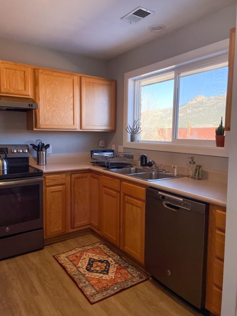 The kitchen includes a dishwasher, stove, oven, and drip coffee maker.