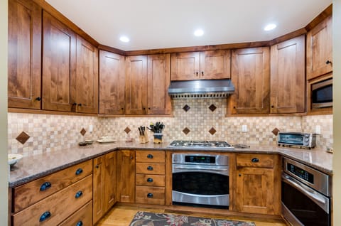 Kitchen with five burner cooktop, two convect ovens.