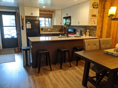 Open concept kitchen & dining with seating for 3 at bar & 6 at table.