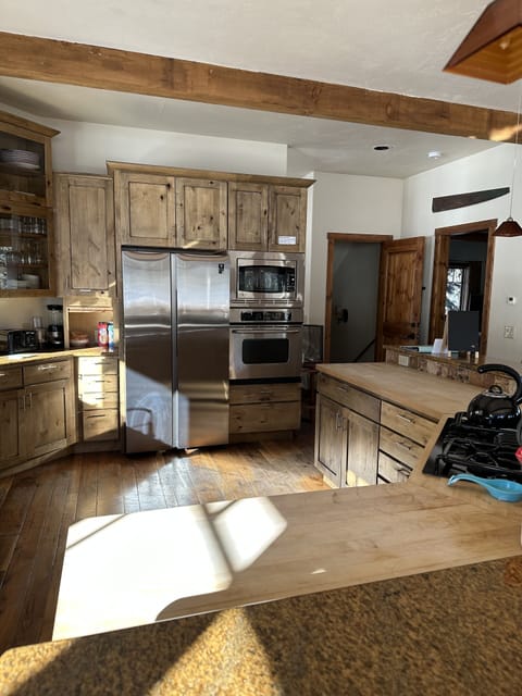 A large kitchen with knotty alder cabinets, granite and wood countertops.