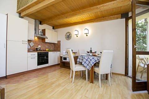 The living room with dinner table, kitchen counter and exit to the balcony