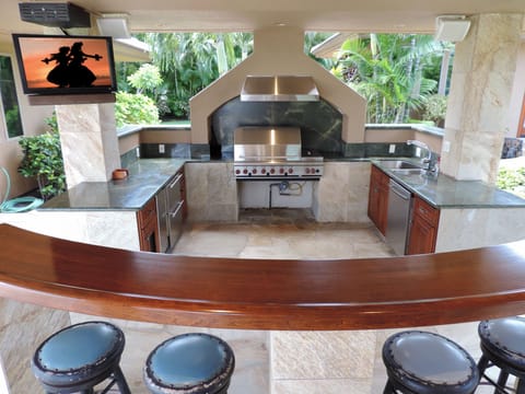 BBQ area with outdoor TV, Wolf grill, refrigerator drawers, sink & bar
