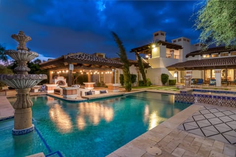 Enjoy this spacious 11-bedroom home featuring a pool, stone fountain, and covered outdoor kitchen. The outdoor area offers a peaceful setting with ambient lighting, perfect for relaxing or spending time with your group.