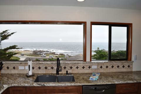 Kitchen sink with granite and tiled backsplash with an ocean view.
