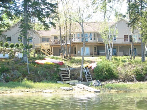 back of home, horseshoe pit , firepit, dock and hot tub