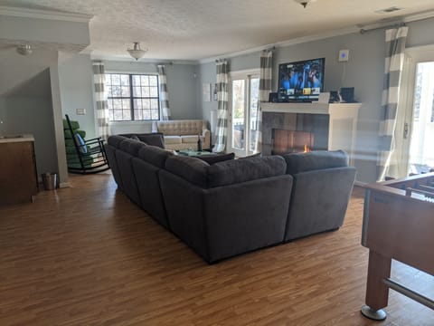 Comfy couch in basement with flaming fireplace