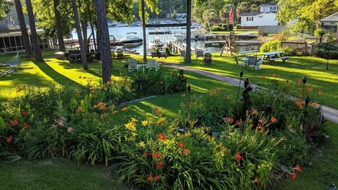 Beautiful yard with tables, chairs, grills, decks, dock, swimming area and more.
