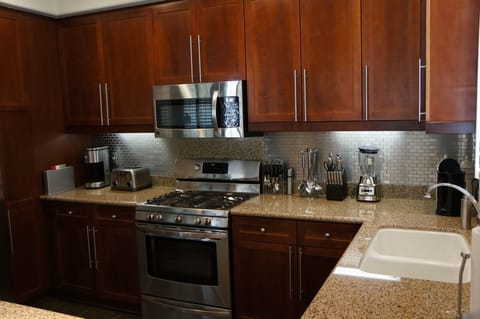 Granite countertops with stainless steel appliances and backsplash