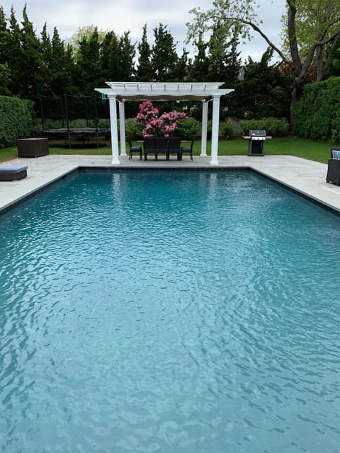 Gunite custom pool with landscaping and covered dining. Viking outdoor grill