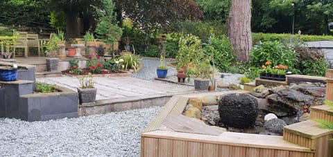 View up the garden, BBQ area at rear and pondless water feature in foreground