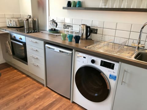Kitchen with oven, hob, fridge, washer dryer, microwave, toaster, kettle