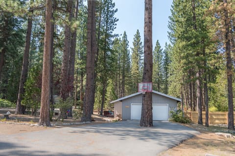 Front of the property featuring large driveway and basketball hoop