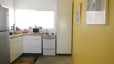 Renovated kitchen with appliances, pots/pans, plates, cup, utensils & staples.
