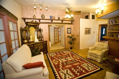 Library, flagstone floor,honey pine 3 sided custom book shelves, sleeper-sofa.