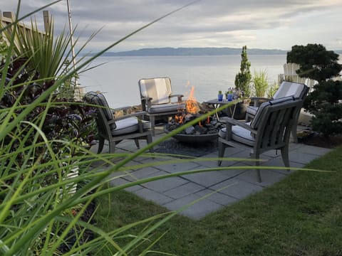 Waterside patio with centrally located fire pit.