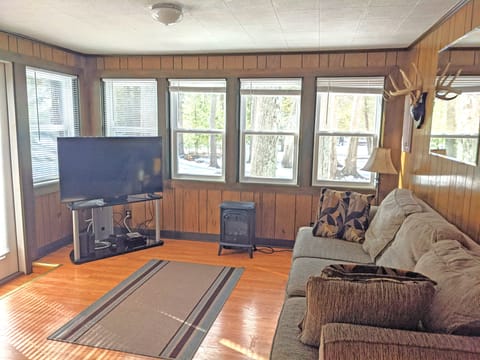 Back living room with wrap around windows and wooded views.
