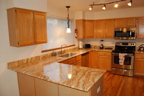 Large kitchen has granite counter tops and many kitchen accessories