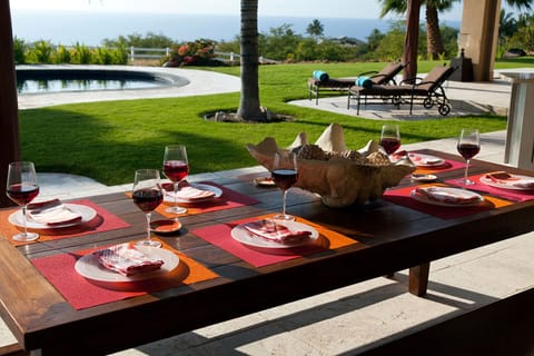 Outdoor dining under covered lanai with ocean and pool views. Ideal climate