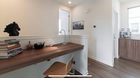 A desk with some essentials and lots of chargers. A monitor and a laser printer