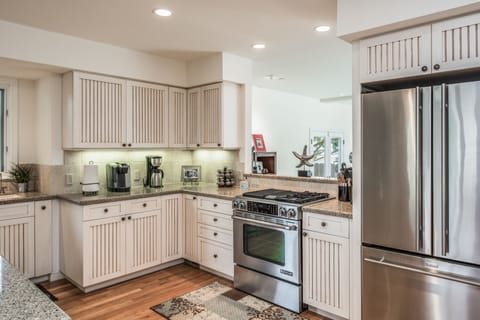The kitchen is open and features a gas range, 2 coffee makers & spice rack.