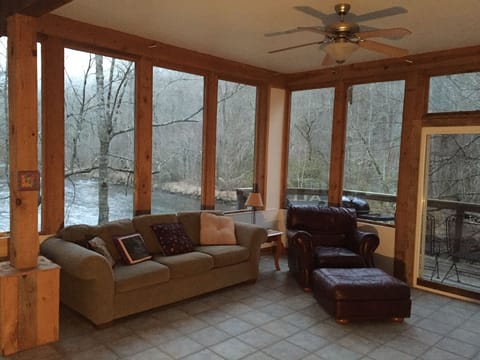 Great room surrounded by windows overlooking the river