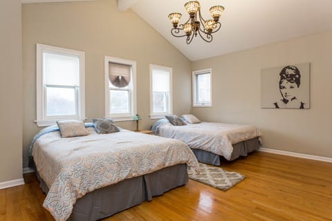 Spacious third floor bedroom with two queen beds and option to add a single bed