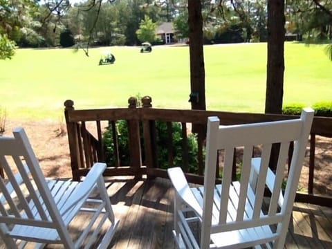 Watch golf from deck in classic Pinehurst white rocking chairs