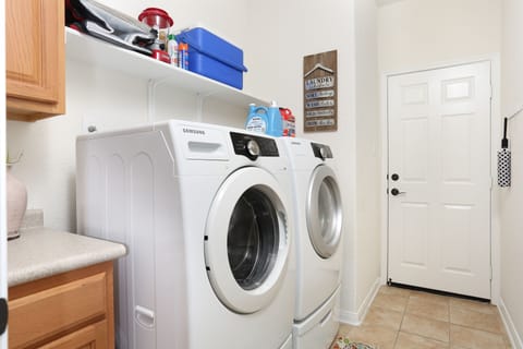 Full laundry room with washer, dryer, detergent and softener. 