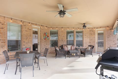 Covered patio with gas grill and seating.