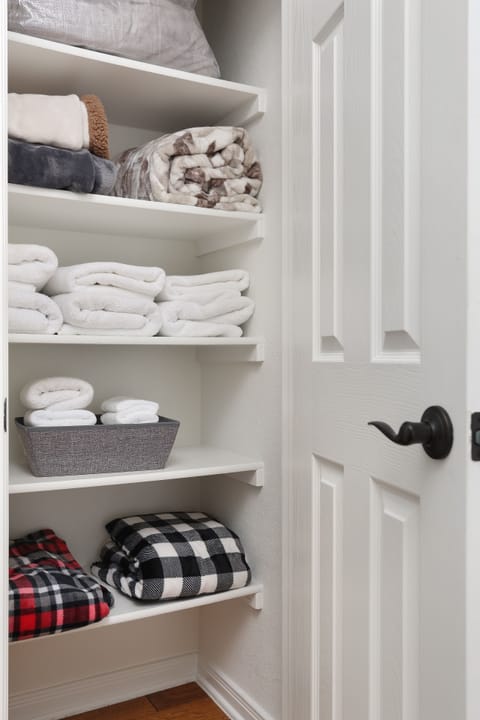 Linen closet with towels and extra blankets.