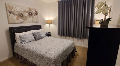 Front secondary bedroom with queen bed and desk,\