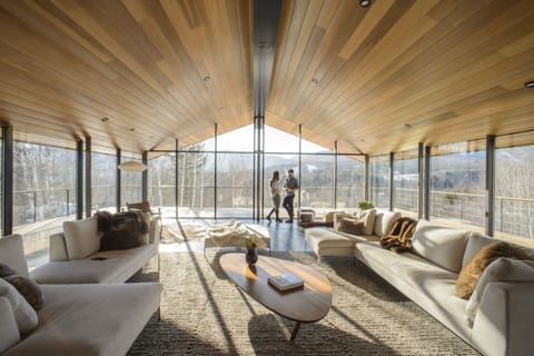 Over-sized living room with glass walls and wraparound decks.