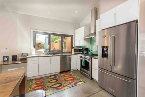 Bright modern kitchen with accordion window that opens to courtyard.