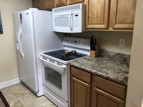 Filly stocked kitchen with granite counter tops and Whirlpool appliances.