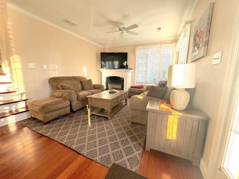 Family room with 55 inch TV, ceiling fan and gas fireplace