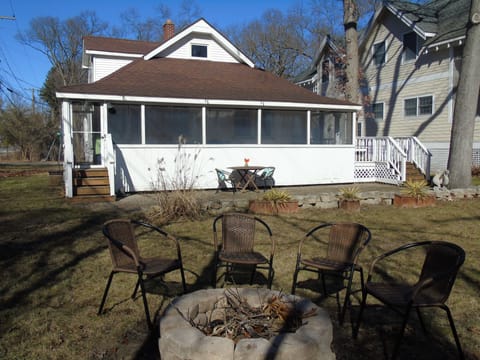 Back view of screened in porch, patio and fire-pit. Outdoor shower on right deck