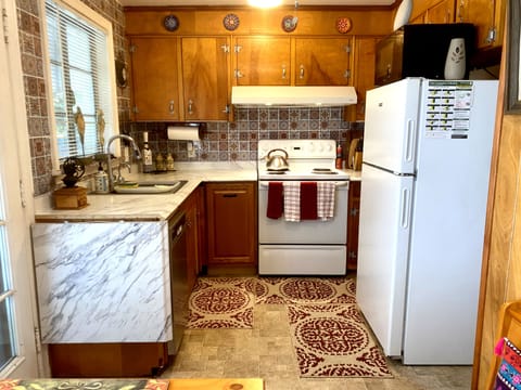 Classic 50’s full of cups, glasses, plates, bowls, & more pots and pans in stove