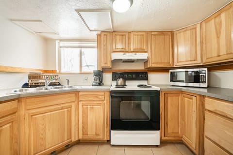 kitchen, microwave, coffee maker, kettle, cutlery and dishes.