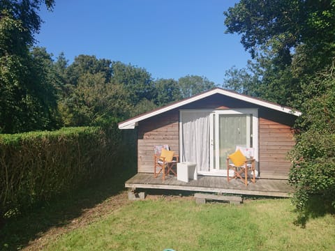 Summer house at the end of the garden with chairs, day bed, books and games.