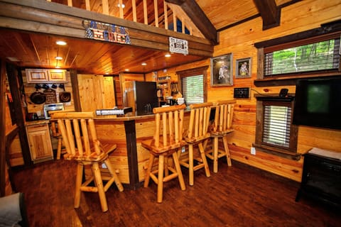 - Rustic cabin bar seating with warm wood beams   - Forest retreat kitchen and dining layout   - Cozy space designed for comfortable cabin gatherings