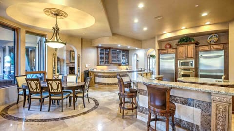 Kitchen, bar, & dining areas w/ luxury appliances, & backyard views