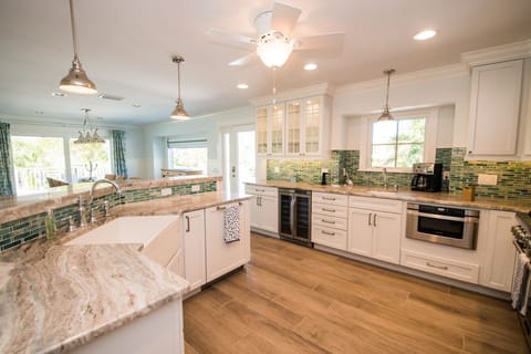 Large Kitchen with Farm Sink, Hand-poured Glass Backsplash and Granite Counters