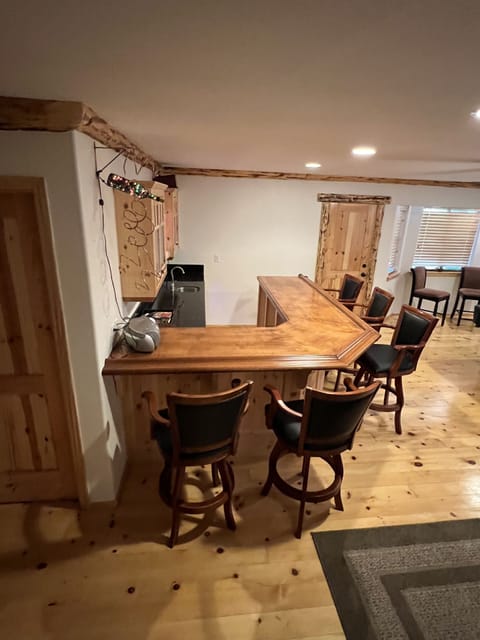 Game room with pool table, poker table, dart board and bar