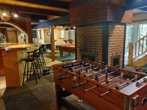 game room with air hockey, wood burning fireplace, wet bar with fridge and sink