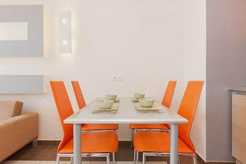 Another view of the dining area with orange chairs, blending seamlessly with the kitchen area for an open, cohesive look.
